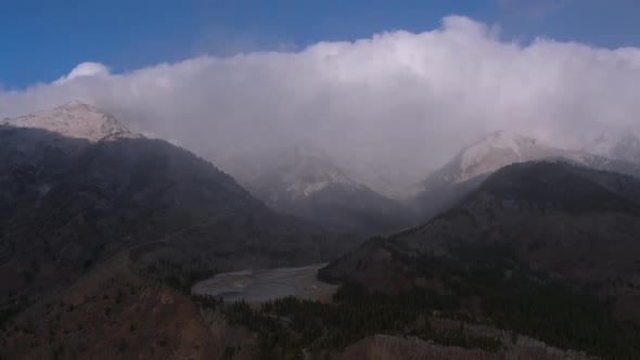 Aerial view over looking vast snowy mountain scenory and a resevoir