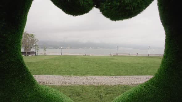 Big Topiary Grass Hands Making Heart Sign Shape in the Park By Sea