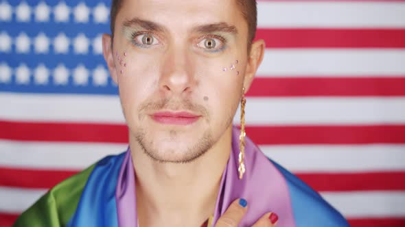 Joyous Gay Man Posing for Camera against American Flag