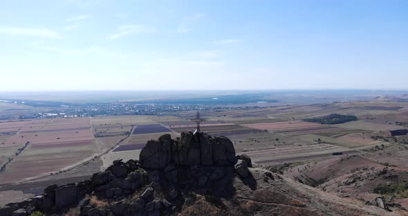 View Of A Cross At Pricopan Peak With Farmland Backdrop In Macin Mountain, Dobrogea