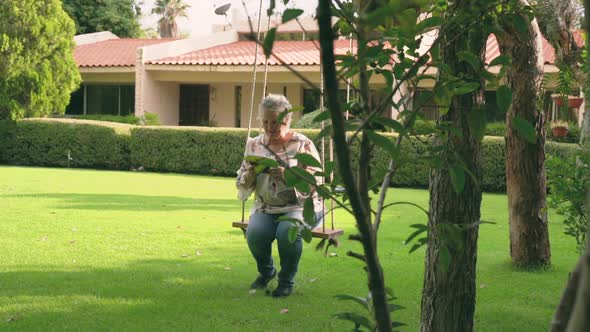 Woman with gray hair sitting outside and reading electronic book