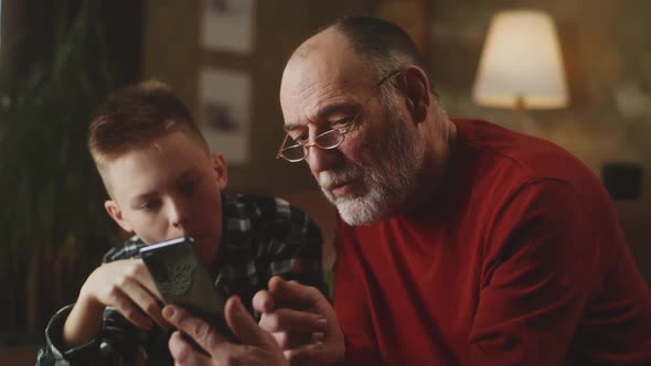 Grandson Teaching Grandfather to Use Smartphone