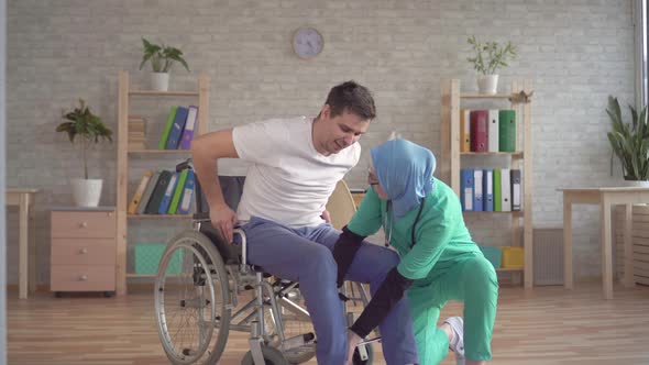 Muslim Nurse in Hijab Helps Disabled Person To Get Up From Wheelchair