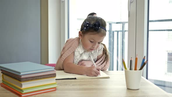 Little Elementary Schoolgirl Doing Homework. Cute Child Learns on His Own. Back To School.