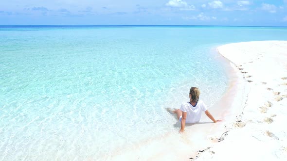 Slow motion: woman sunbathing relaxing in turquoise water white sand beach tropical sea Indonesia