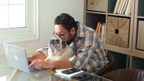 Portrait of man and dog working together at home with laptop computer - concept of free smart work
