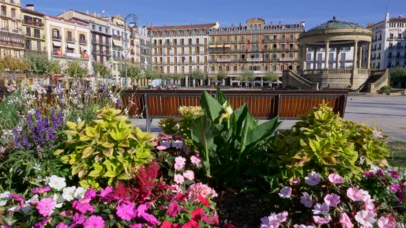 Pamplona, Spain. Bright Colored Flowers By a Bench on a Plaza Del Castillo. Lifting Shot Over