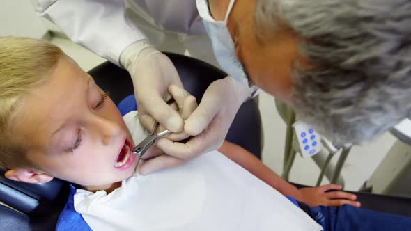 Dentist examining a young patient with tools