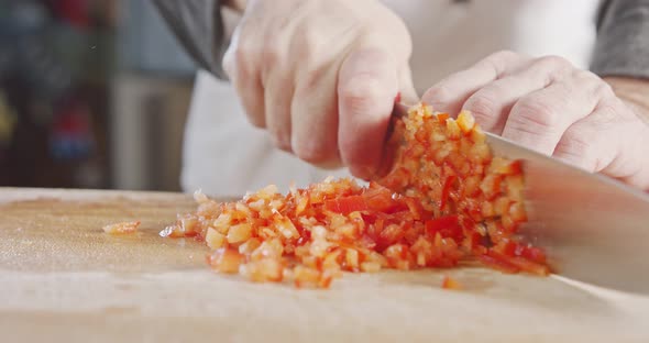 Slow motion close up of a chef knife slicing a Red bell pepper