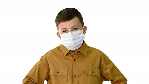 Boy Wearing Protective Face Mask Looking at Camera on White Background