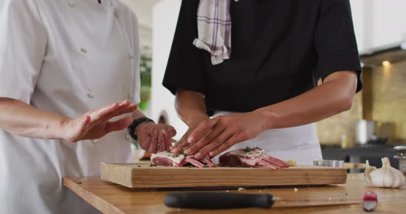 Caucasian female chef teaching diverse group wearing face masks