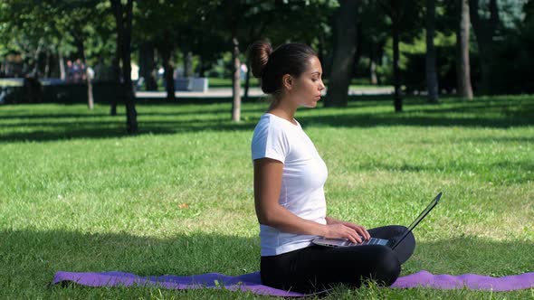 Woman Yoga in the Park Working on a Laptop