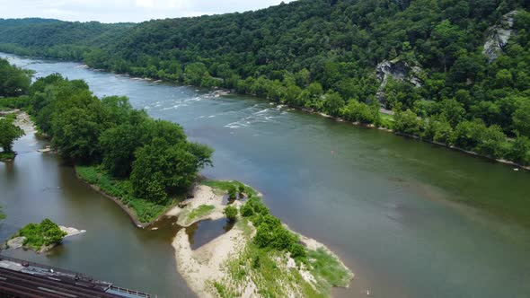 The Potomac River near Harper's Ferry, West Virginia as a train crosses the river on a bridge.