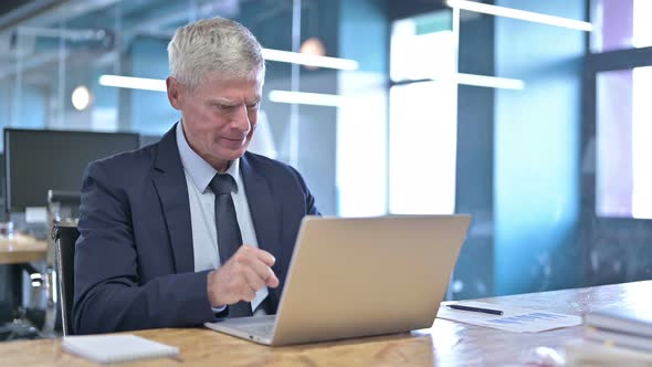 Upset Middle Aged Businessman Working on Laptop