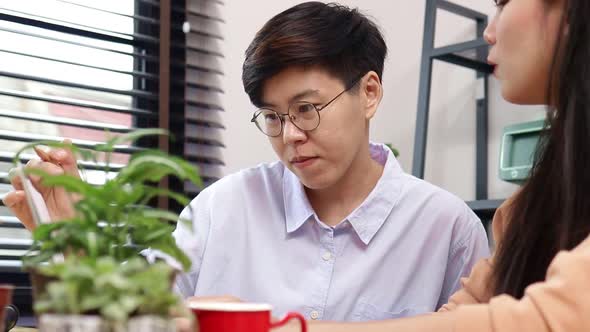 Asian LGBT couples work together at home. Small business entrepreneurs.