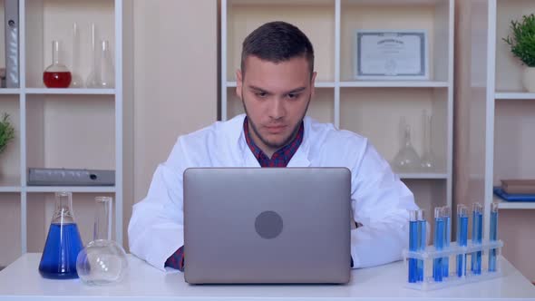 Laboratory Assistant Typing on Laptop