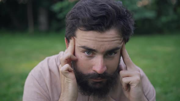 Closeup Portrait of Sad Ill Man Rubbing Temples Suffering Chronic Migraine Headache