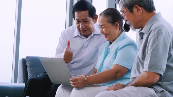 Group of senior friends using laptop in a retirement home