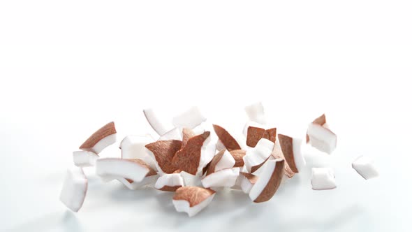 Super Slow Motion Shot of Falling and Breaking Fresh Coconut on White Background at 1000Fps