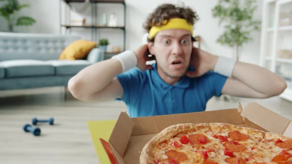 Slow Motion of Bizarre Sportsman Doing Crunches and Stretching Arms to Pizza Exercising Alone in