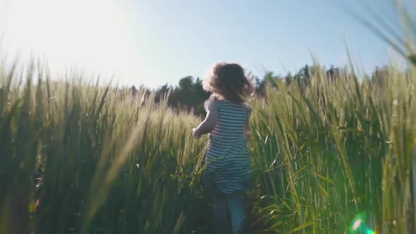 Joyful child running across a wheat field in the sun