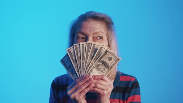 Portrait of Friendly Old Woman with a Fan of Dollar Bills