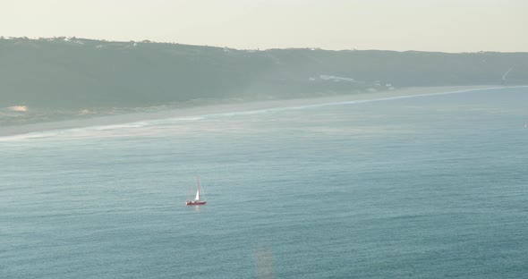 Boat Sailing On Calm Ocean During Misty Sunrise Morning In Praia do Norte, Nazare, Portugal. - Stati