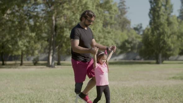 Tracking Shot of Handicapped Dad Lifting Daughter By Hands