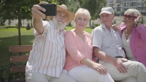 Two Cute Fun Adult Couples Sitting on the Bench Together