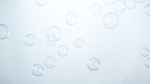 Super Slow Motion Shot of Flying Colorful Soap Bubbles on Light Blue Background at 1000 Fps