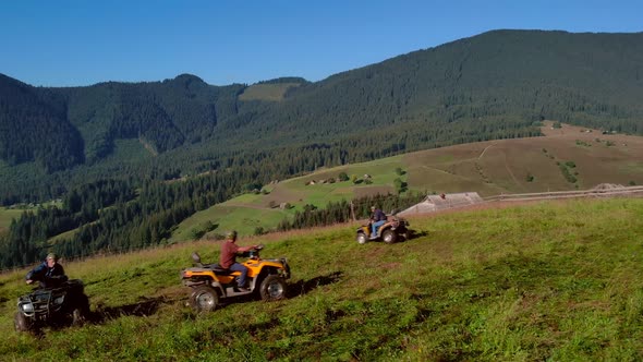 Tourists Riding Quad Bikes on Mountain Forests Background