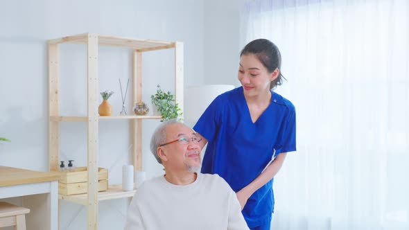Portrait of Asian caregiver nurse take care senior male on wheelchair.
