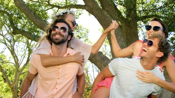 Hipster boys carrying girls on their shoulder