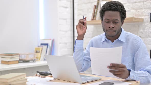 Ambitious African Man Reading Documents