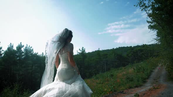 Girl in a wedding dress runs on nature. Slow motion