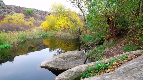 A Fast Clean Stream Runs Among Smooth Wet Stones Surrounded By Tall Dry Lumps