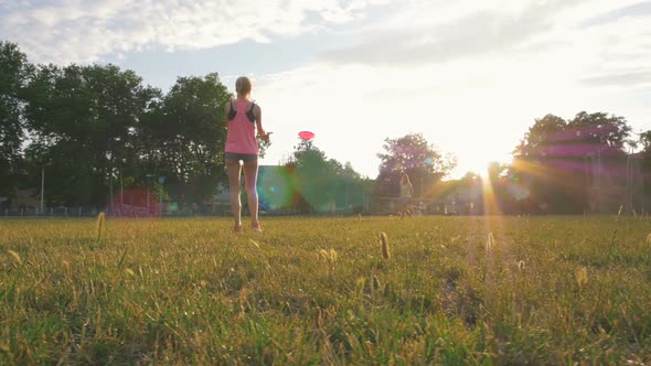 Two Young and Beautiful Women Playing Frisbee in the Park Slow Motion