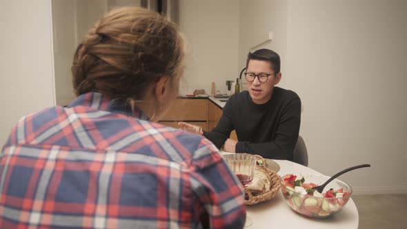 Multi-ethnic couple having dinner at home