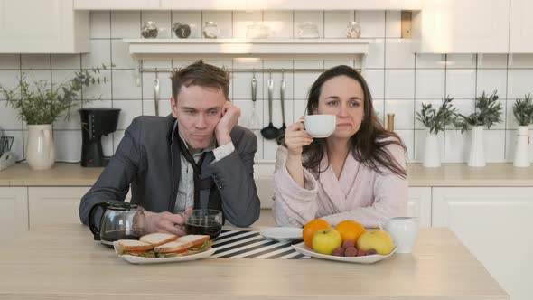 Exhausted Couple Drink Coffee in Morning at Home