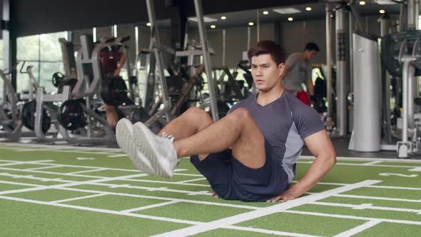 Handsome young athlete Asian guy exercise doing push-ups fat burning workout in fitness class.