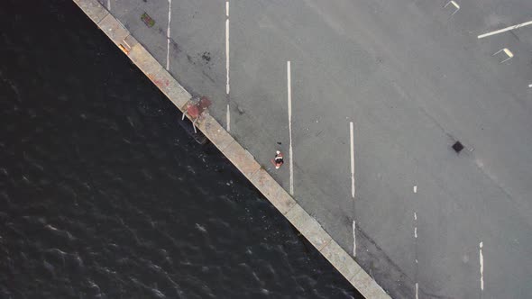 Drone Over Woman At Harbour Then Turning To Jog Away