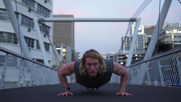 Sporty Caucasian man training on a bridge