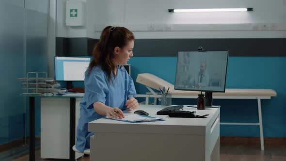 Medical Assistant Using Video Call to Talk to Doctor on Computer