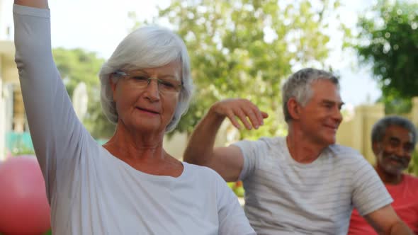 Senior friends doing exercise in garden 4k