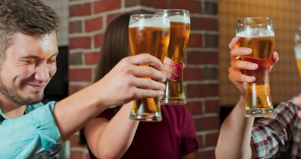 Group of Friends Enjoying a Beer at Pub in Poland Toasting and Laughing  Multiracial