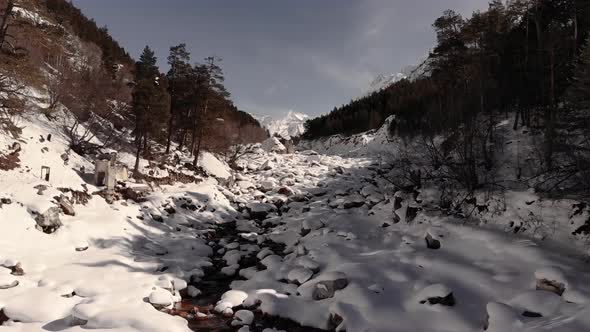 Winter Forest and Snowcapped River with a High Iron Content in Drifts of White Snow High in the