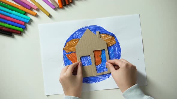 Kid Putting Paper House and Heart Sign Near Earth Painting, World Our Home