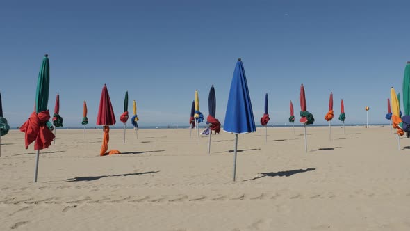 DEAUVILLE, FRANCE - SEPTEMBER 2016 Colorful parasols in a row of famous film festival city with sun 