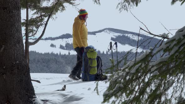 A Man with a Backpack Travels in the Mountains in Winter