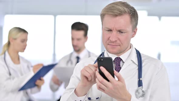 Portrait of Doctor Using Smartphone at Clinic